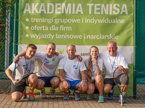 Trenerzy tenisa z rakietami pod banerem akademii
