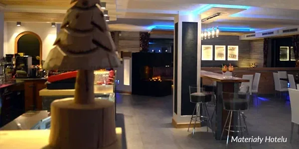 Hotelowy bar z wysokimi stołkami i kominkiem
