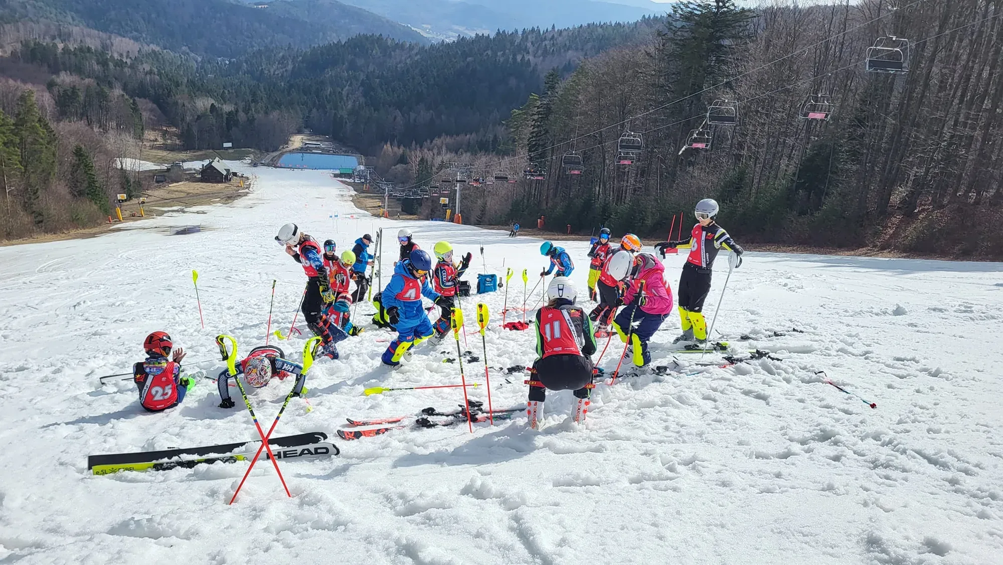 Grupa ćwiczy między tyczkami na stoku