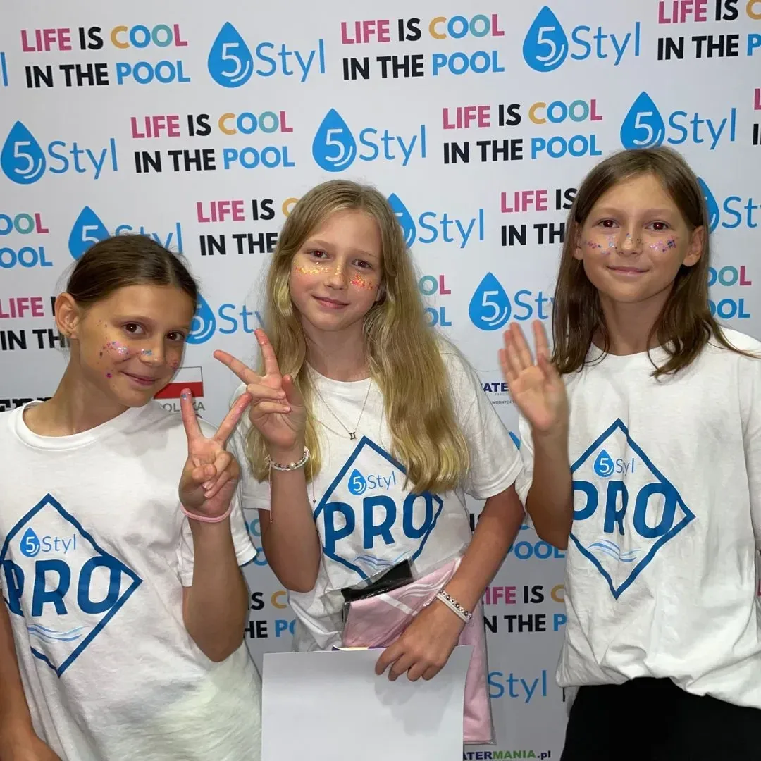 Trzy uczestniczki w koszulkach PRO przy ściance z logo 5Styl