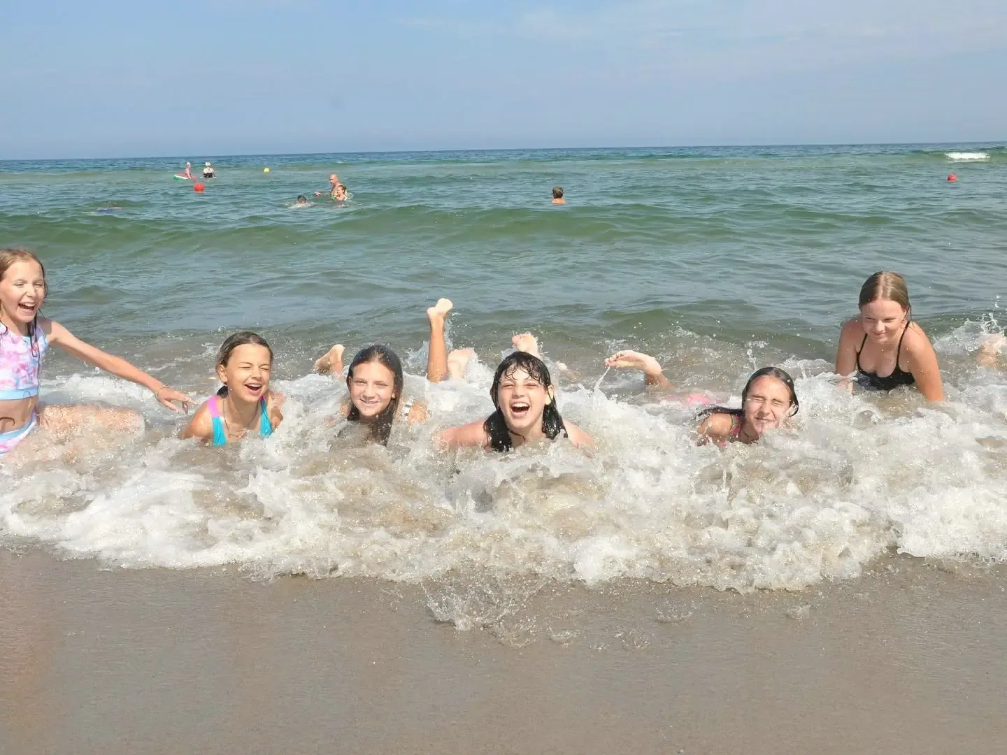 Grupa uczestniczek w falach przy plaży