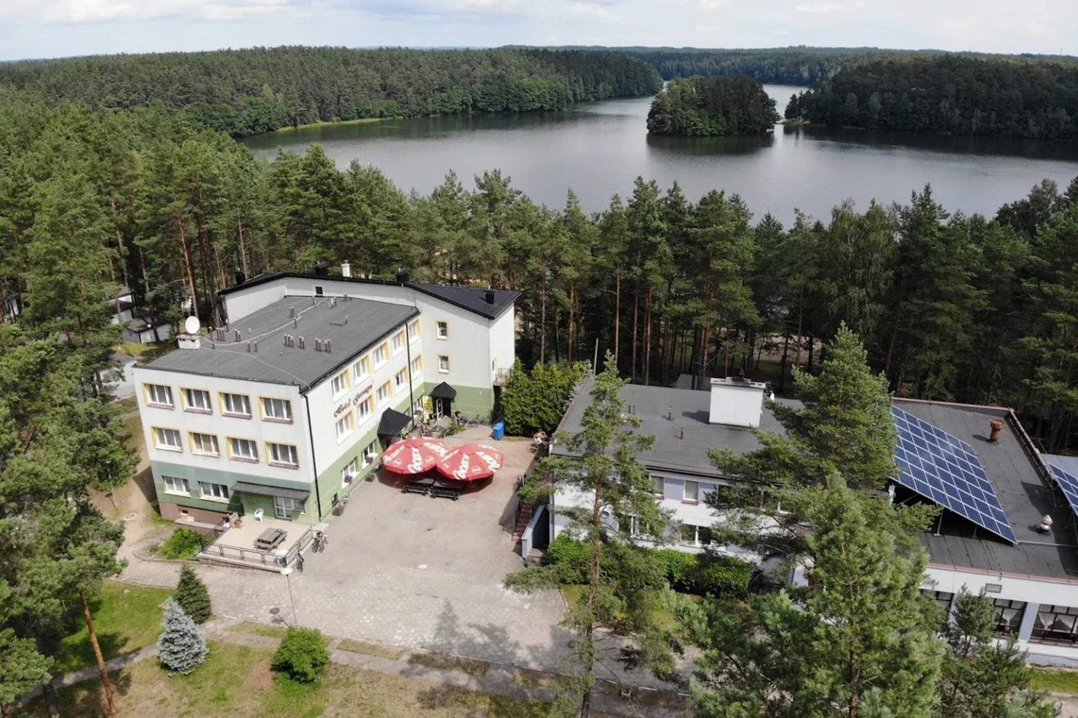 Ośrodek nad jeziorem Garczyn z lotu ptaka, budynki wśród sosen
