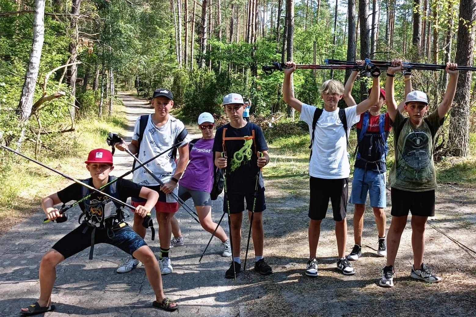 Grupa z kijkami do nordic walkingu na leśnej drodze