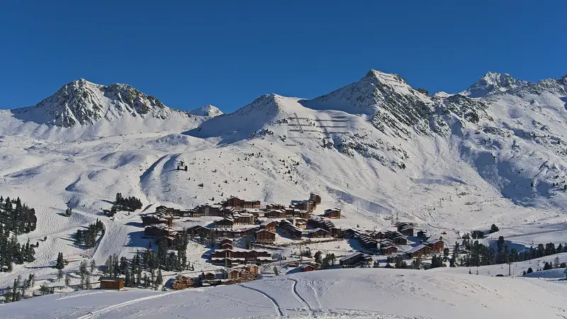 Belle Plagne widziana z trasy zjazdowej, zabudowa ośrodka na zaśnieżonym zboczu