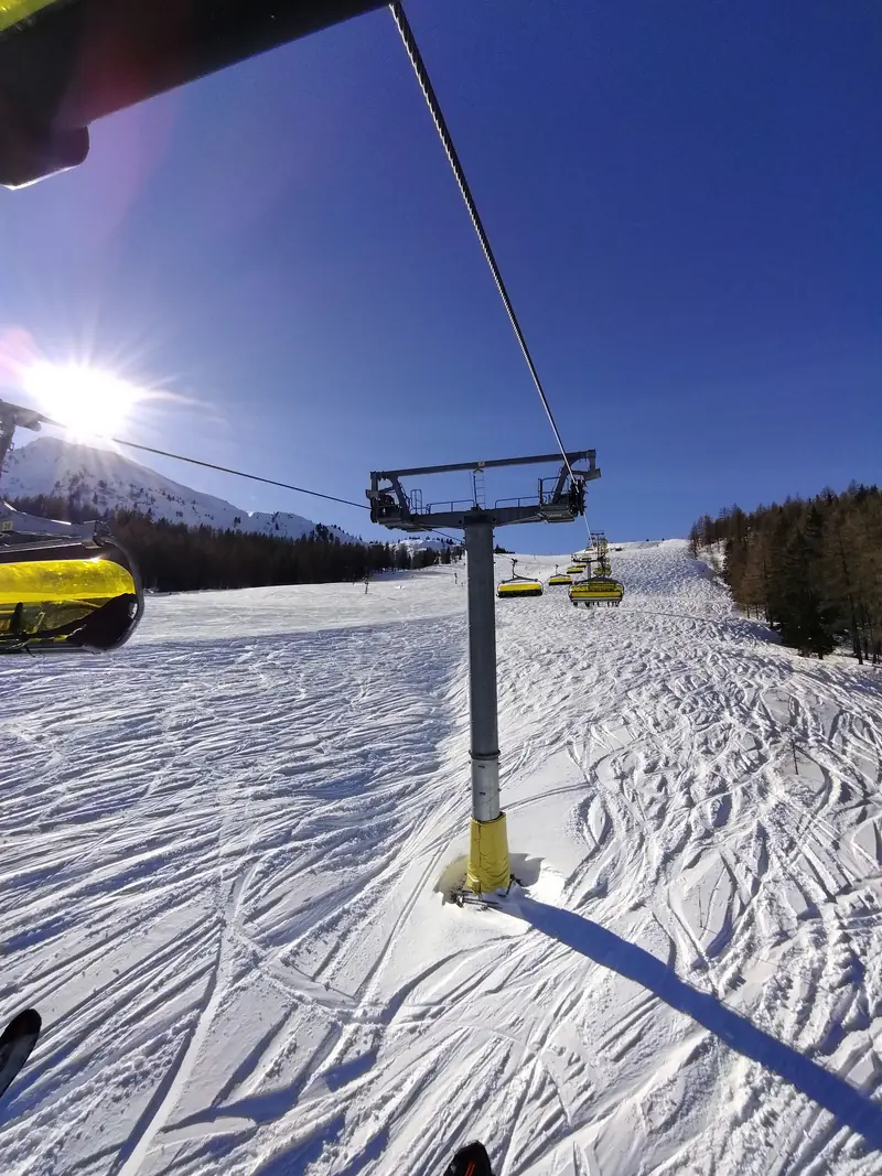 Słoneczny stok Planai w Schladming, linia wyciągu krzesełkowego nad wyratrakowanym śniegiem