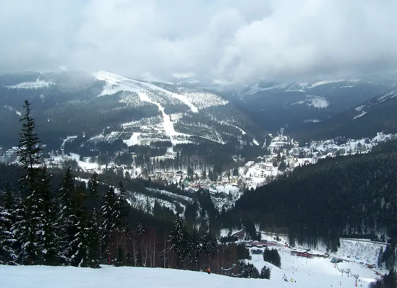 The snowy Svatý Petr valley at Špindlerův Mlýn, ski runs on the slopes and the village below