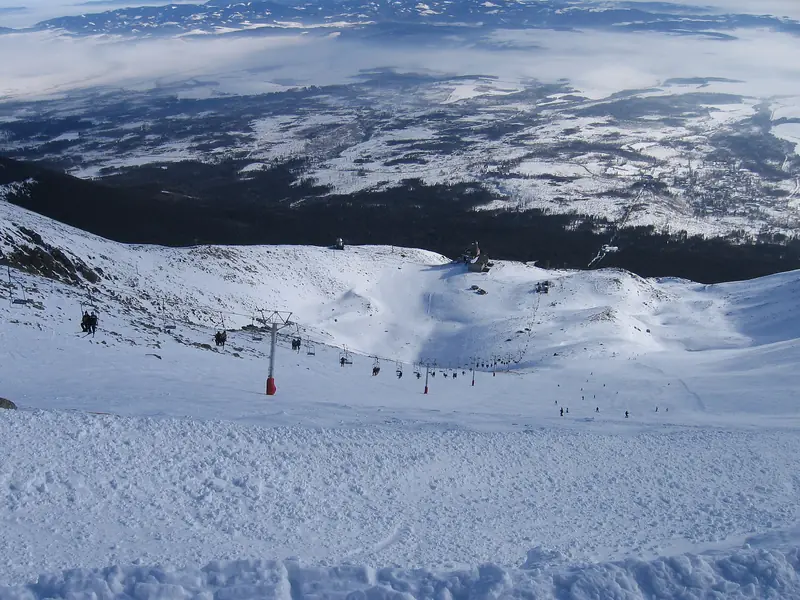 A broad snowy piste below Skalnaté pleso at Tatranská Lomnica, a High Tatra panorama
